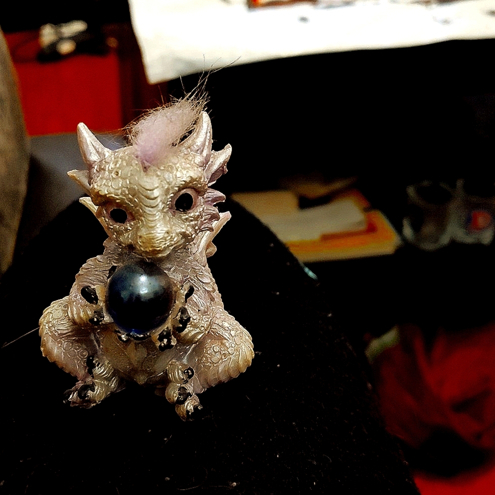 Cute Dragon holding a crystal 🔮 figurine made out of clay.